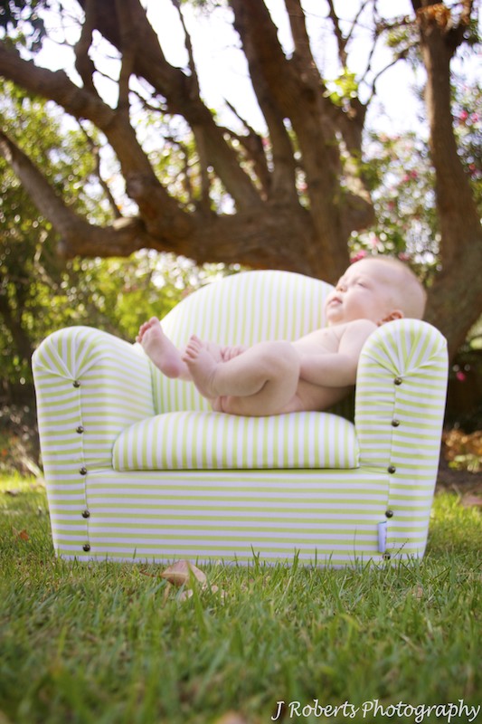 Baby lounging on couch in garden - baby portrait photography sydney